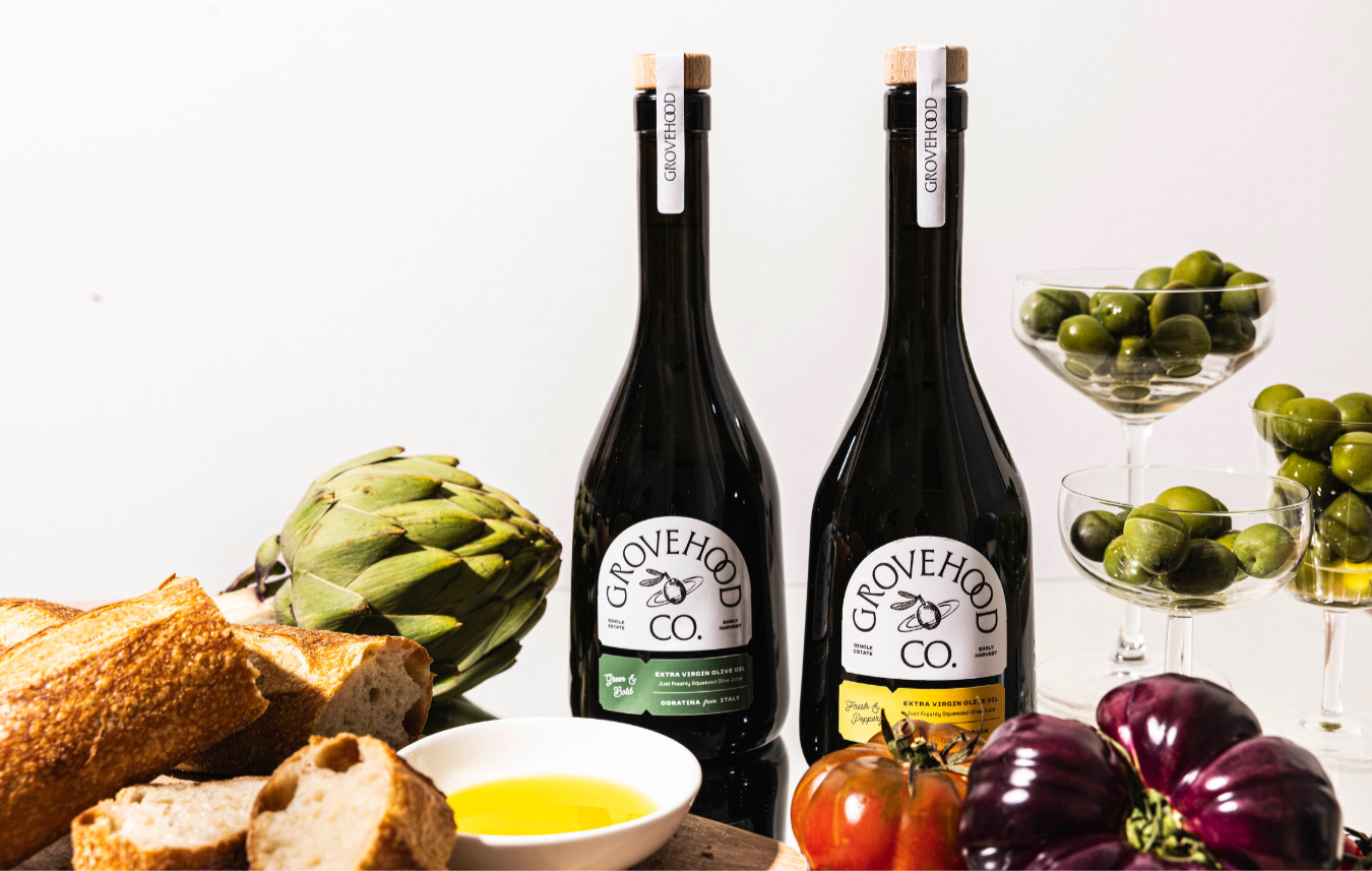 Grovehood Collective Extra Virgin Olive Oil bottles at a dinner table