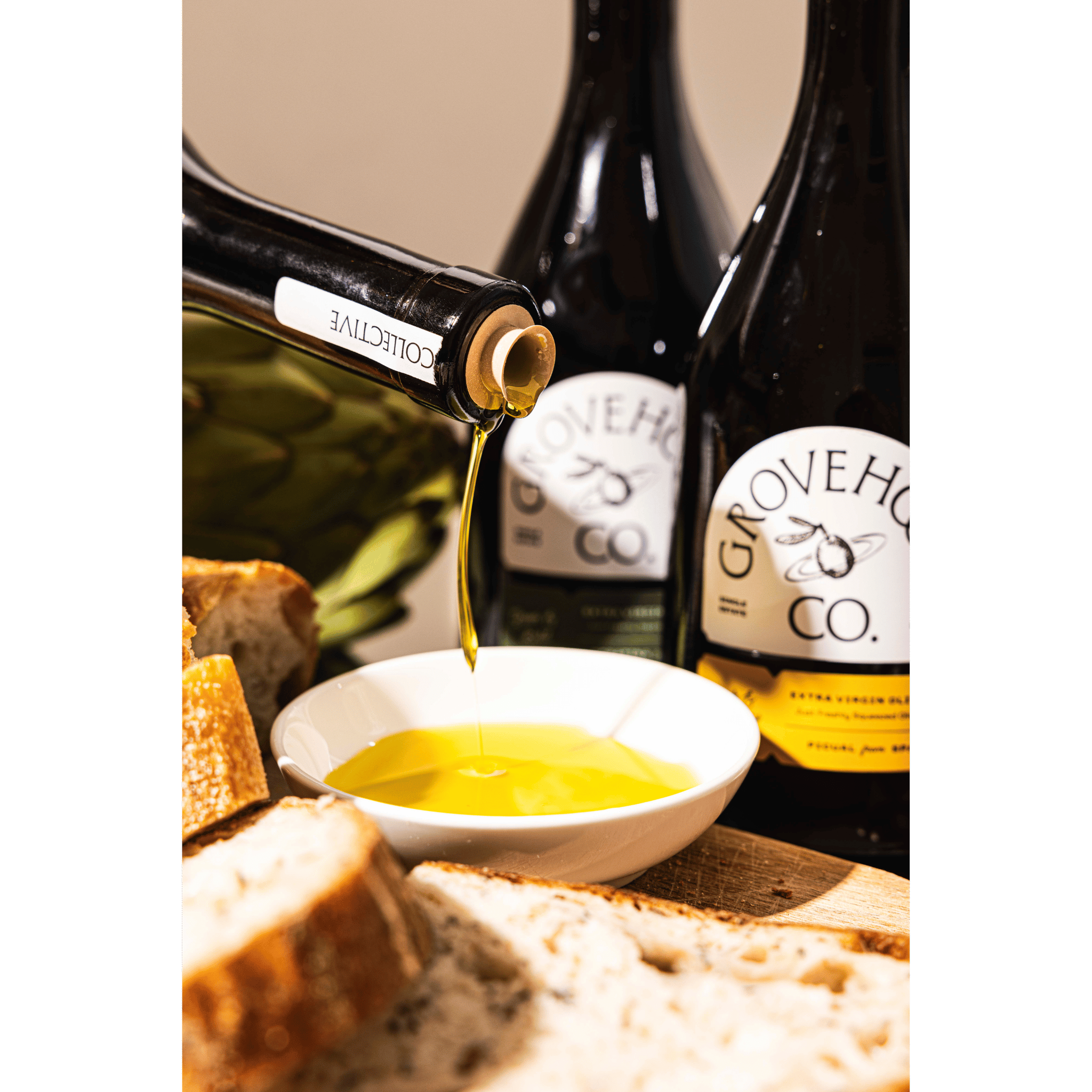Grovehood Collective Spanish & Italian extra virgin olive oil bottle at a table with bread