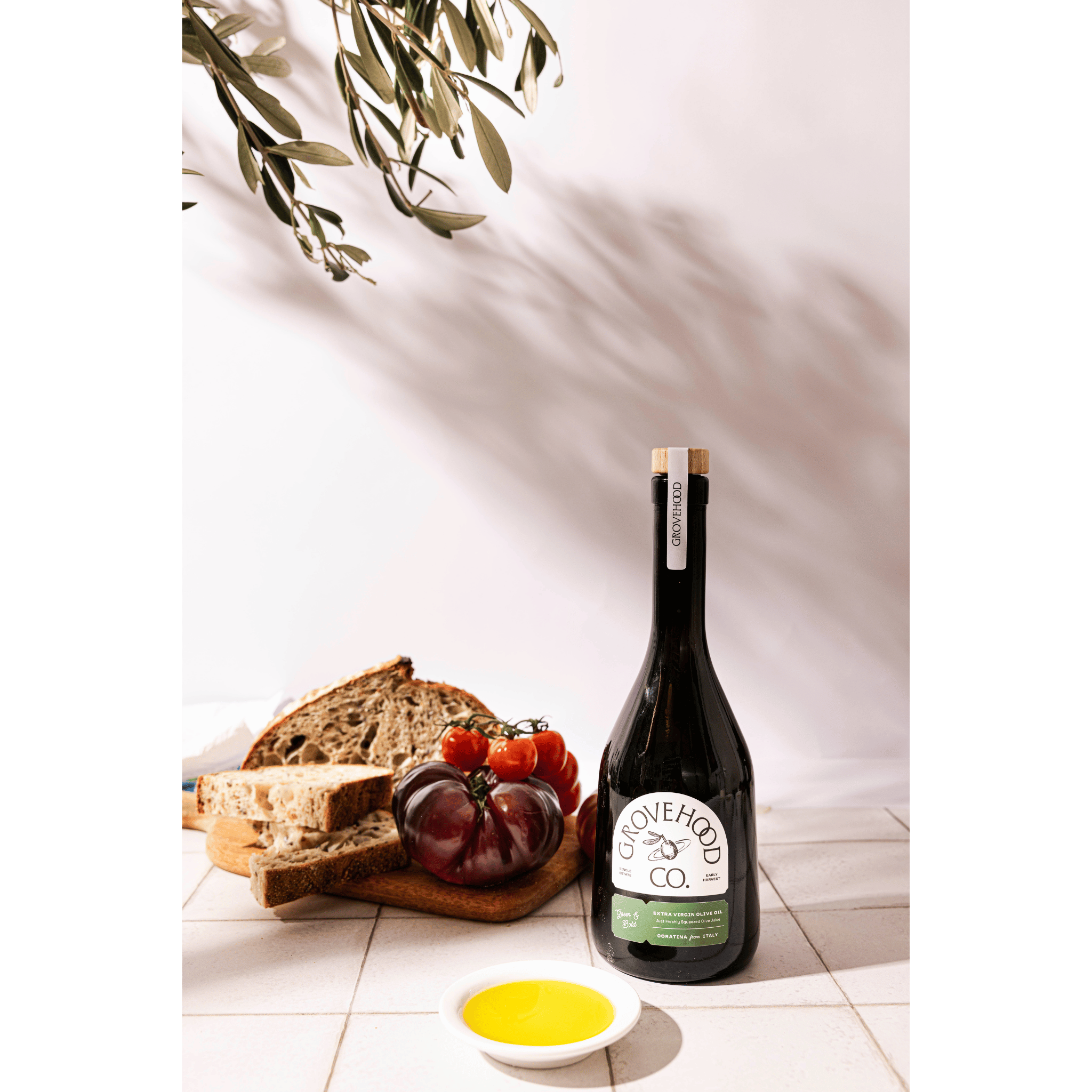 Grovehood Collective Italian extra virgin olive oil bottle with bread and tomatoes