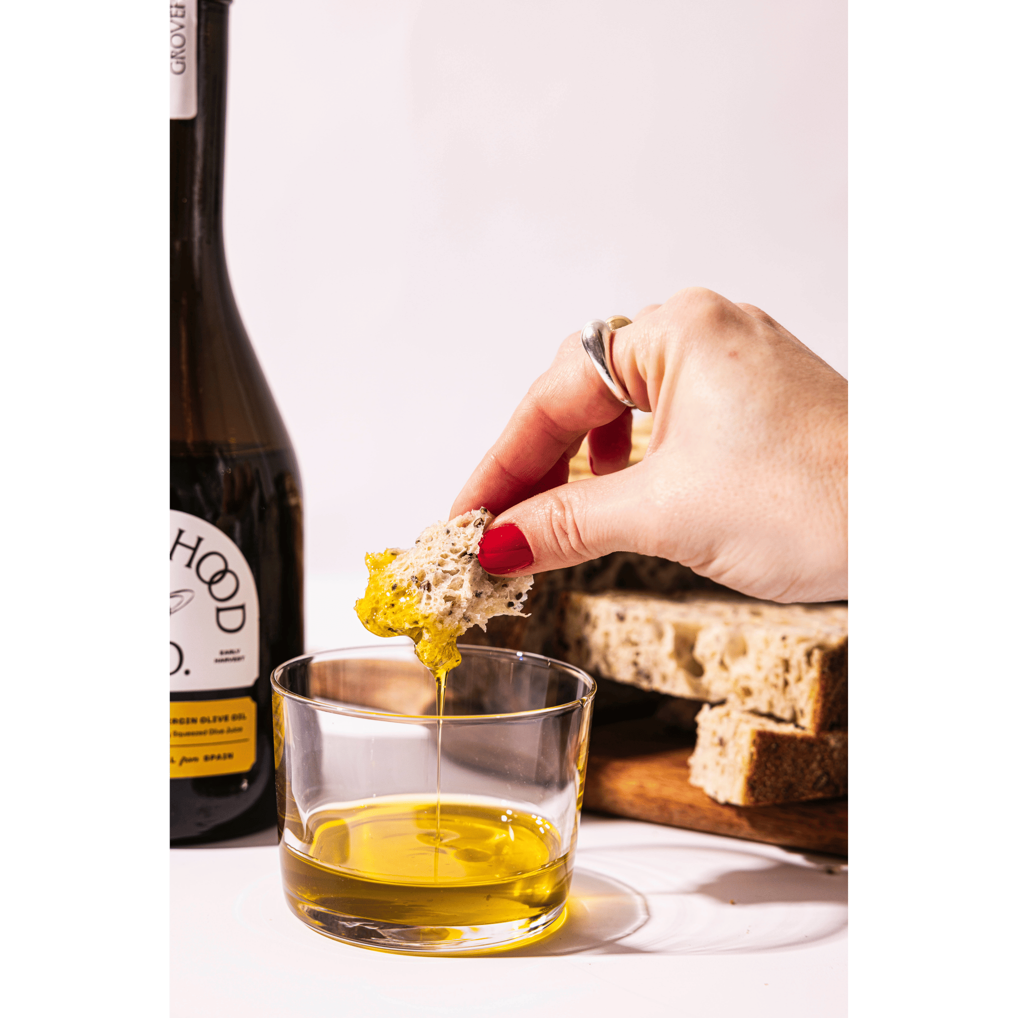 Grovehood Collective Spanish extra virgin olive oil being dipped with bread
